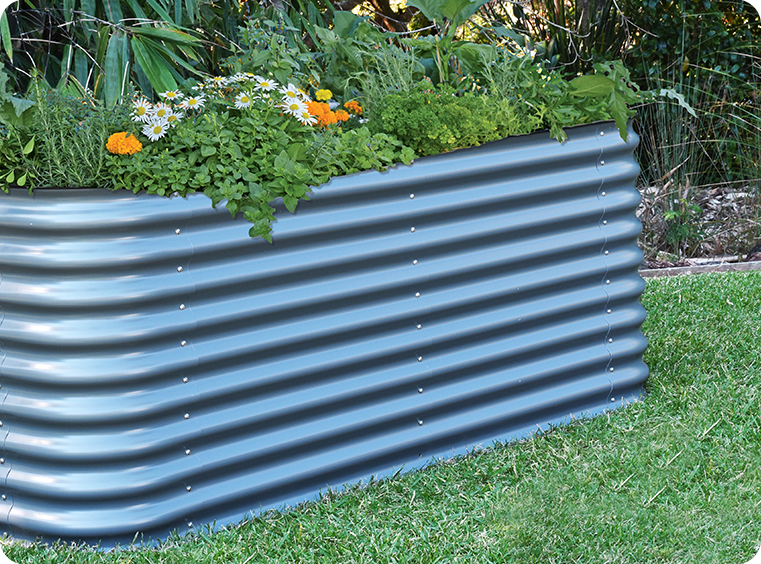 Metal raised garden bed with plants and flowers in a garden setting